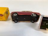 a small red toy car next to a yellow box