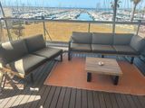 une photo d'un balcon avec des canapés et une table basse