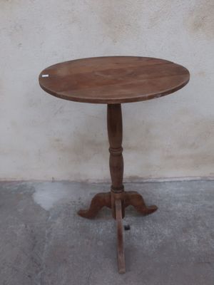 a small table with a wooden top on a concrete floor
