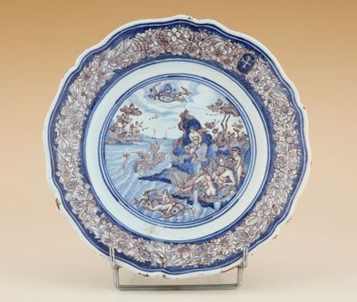 une image représentant une assiette bleue et blanche sur laquelle figure une femme dans un bateau