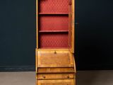 an old wooden cabinet with a red upholstered door