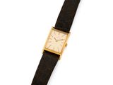 un gros plan d'une montre sur une surface blanche avec un fond blanc