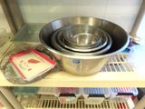 a large metal bowl sitting on a shelf in a kitchen