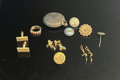 a lot of gold and silver jewelry on a black table