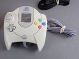 a video game controller sitting on a table next to a charger