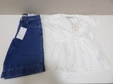 two pairs of jeans and a white shirt are on a table