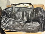 black leather handbag sitting on top of a cardboard box
