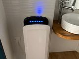 des toilettes blanches surmontées d'une lumière bleue, dans une salle de bains