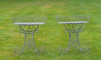deux jardinières en métal posées sur l'herbe dans le jardin
