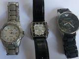 three watches are sitting next to each other on a white surface