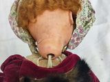 a doll with a red hair wearing a purple coat and a hat