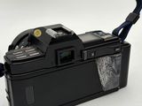 an old camera with a strap attached to it on a white surface