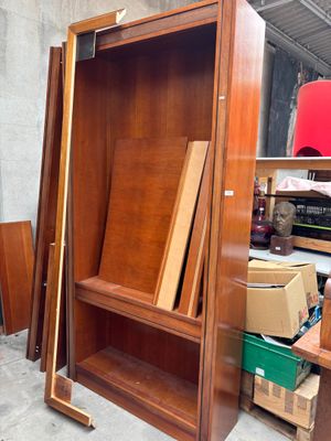 une armoire en bois dont la porte est ouverte, dans une pièce