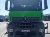 un camion Mercedes vert garé sur un parking
