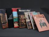 Plusieurs livres sont alignés sur une table devant un fond noir.