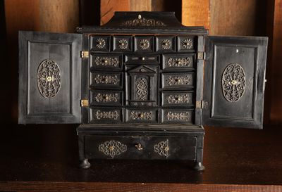 une petite armoire noire dont la porte est ouverte, posée sur une table