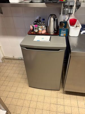 a small kitchen with a stainless steel refrigerator and dishwasher