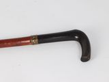 an old cane with a wooden handle on a white surface