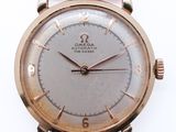 une image d'une montre en or avec un bracelet en cuir marron