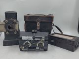 four old cameras sitting on a table next to each other
