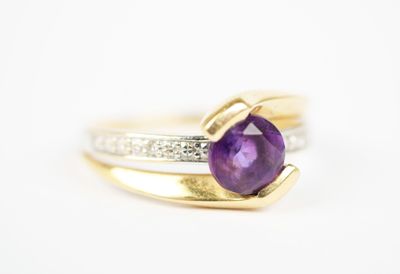 a close up of a ring with a purple stone on top of it