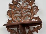 carved wooden shelf with a decorative design on top of it