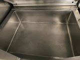 a stainless steel sink in a kitchen with a black counter top