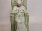 a figurine of a woman sitting in a chair