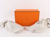 an orange box with a pair of shoes in it and a pair of gloves in it