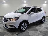 Le SUV Buick blanc est garé sur un sol carrelé à damier.