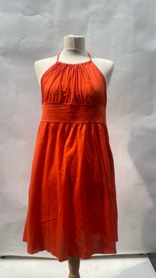 an orange dress on a mannequin display in a store window