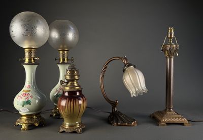 Plusieurs lampes anciennes sont alignées sur un fond gris