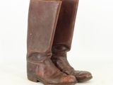 an old pair of brown leather boots on a white background