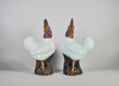 Paire de grands coqs en porcelaine, debout sur des rochers, …