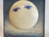a painting on a easel with a painting of a moon in the background