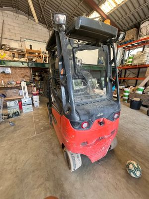 un chariot élévateur rouge garé dans un entrepôt