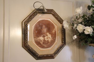 un tableau accroché au mur à côté d'un vase de fleurs