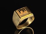 a gold signet ring with the letter f on it