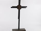 une image représentant une croix en métal posée sur un socle en bois
