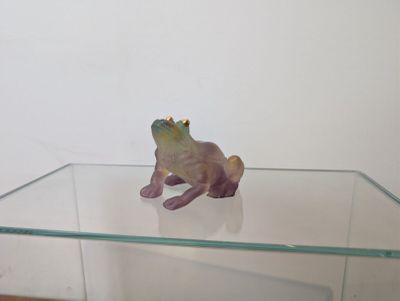 une étagère en verre sur laquelle est posée une figurine de grenouille