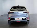the rear end of a silver car in a white room