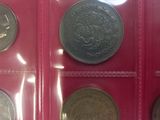 several different types of coins are displayed in a display case