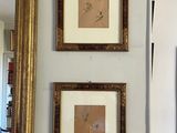 trois tableaux encadrés accrochés au mur au-dessus d'un miroir