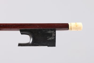 a close up of a violin bow on a white surface