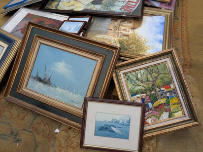 a lot of framed pictures on the floor of a room