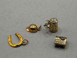 a group of gold charms including a horseshoe, a bell, and a bell