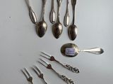 several spoons, forks, and spoon spoons are laid out on a table