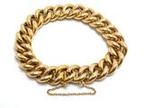 une image représentant un bracelet en or muni d'une chaîne, sur fond blanc