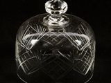 a clear glass dome with a lid on a black background