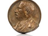une image représentant une médaille de bronze sur laquelle figure le visage d'un homme